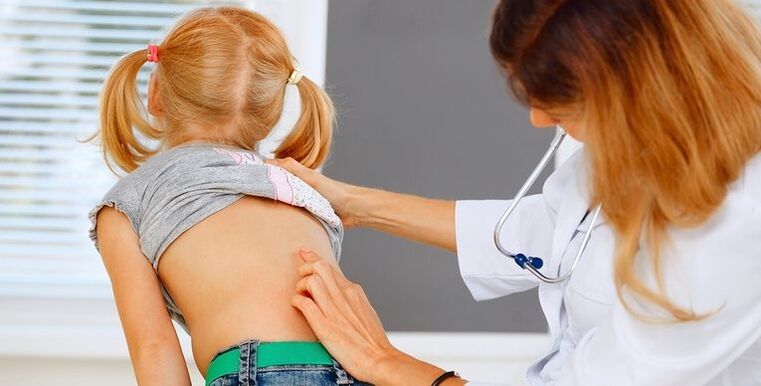 Doktor bir çocuğun sırtını bel ağrısı açısından inceliyor